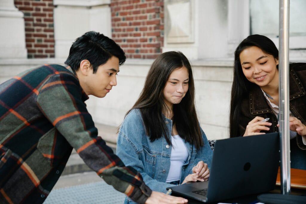 Students studying together on a university campus with a laptop