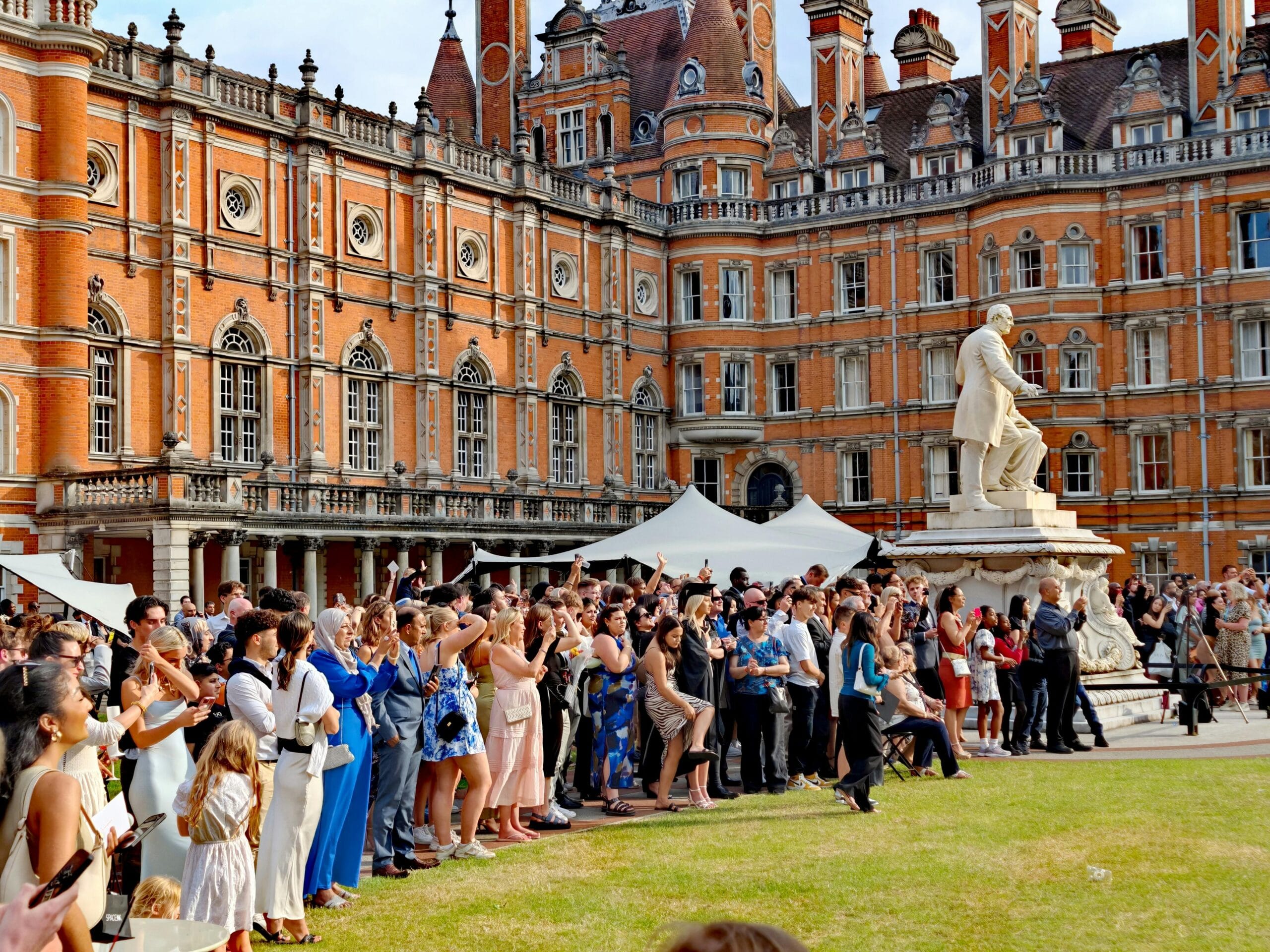 Crowd gathered in a university courtyard in front of a historic building